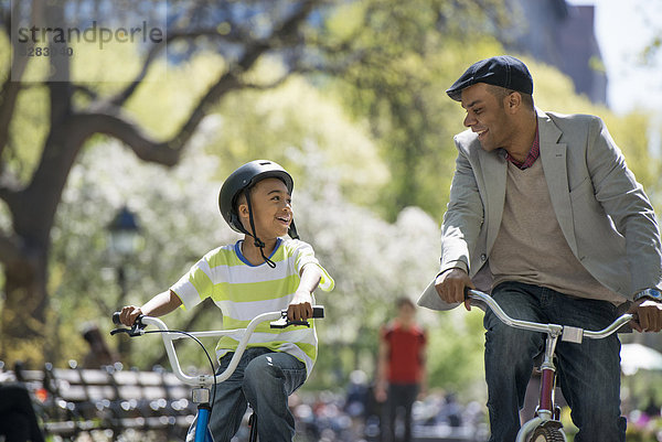 Radfahren und Spaß haben. Ein Vater und Sohn Seite an Seite.