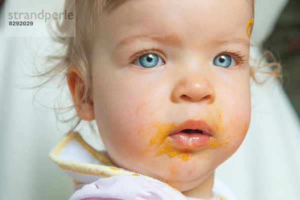Kleines Mädchen mit Essen auf dem Mund