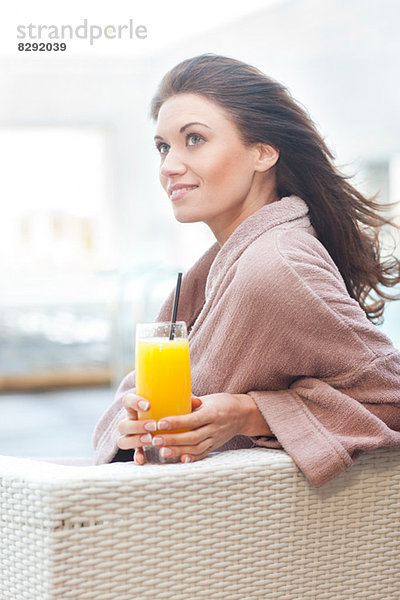 Frau am Hotelpool mit Orangensaft