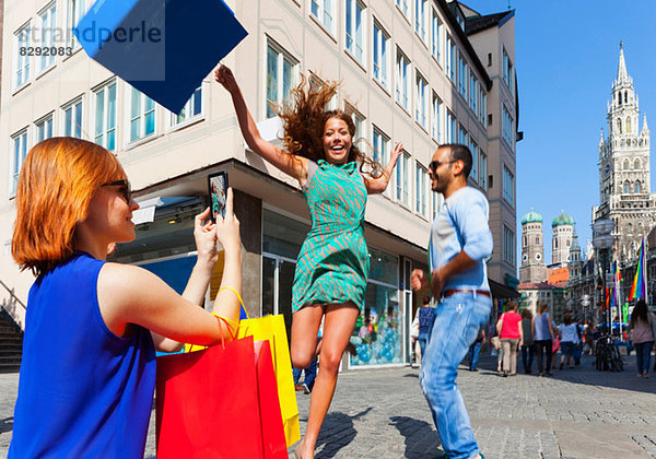 Frau springt mit Einkaufstasche in München Marienplatz  München  Deutschland