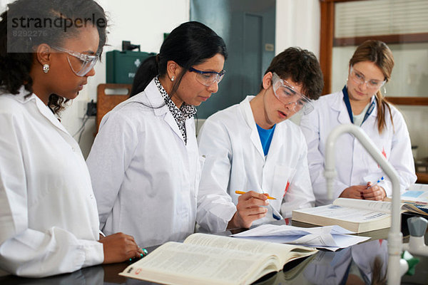 Chemielehrer und Schüler mit Lehrbüchern