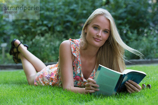 Junge Frau schaut aus dem Buch auf