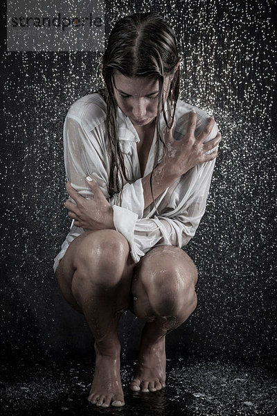 Frau in getränktem Hemd unter der Dusche