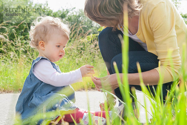 Mutter und Tochter schauen auf das Gras