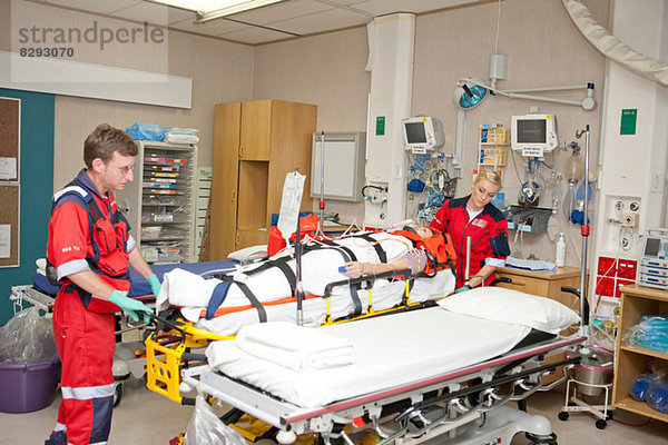 Rettungssanitäter bringen Patienten ins Krankenhausbett