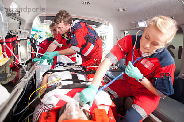 Rettungssanitäter mit Stethoskop am Patienten in der Ambulanz