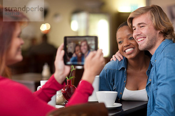 Gruppe von Freunden im Cafe mit digitalem Tablett