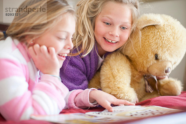 Schwestern und Teddybären lesen Märchenbuch