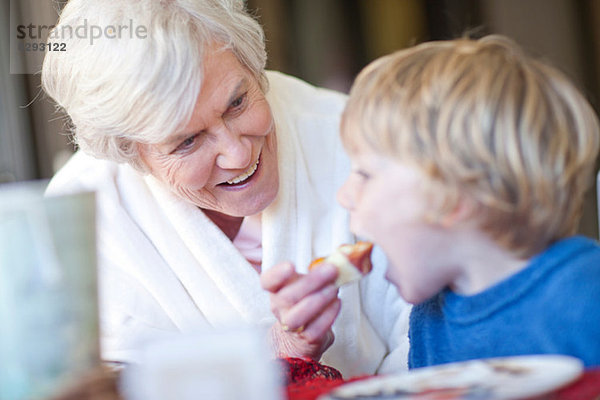 Großmutter füttert Enkelfrühstück