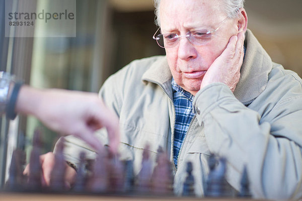 Senior Mann spielt Schach mit Sohn