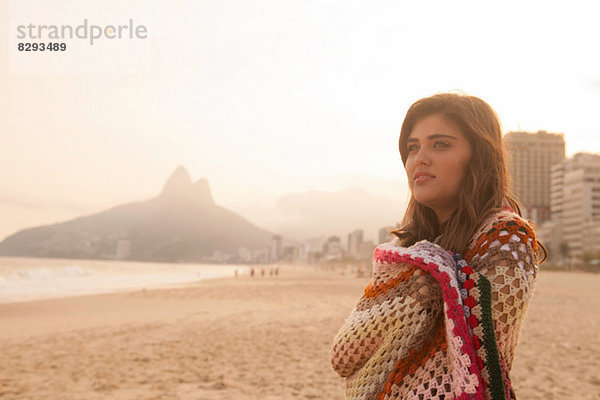 Junge Frau in Decke gewickelt  Ipanema Beach  Rio de Janeiro  Brasilien