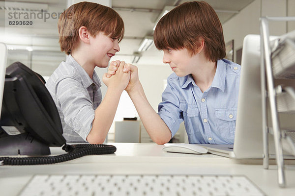 Zwei Jungen Armdrücken im Büro