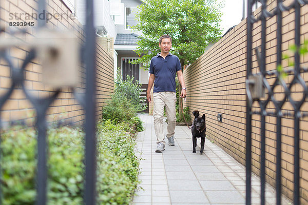 Mann geht mit seinem Hund spazieren
