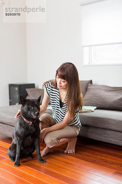 Frau mit Hund im Wohnzimmer