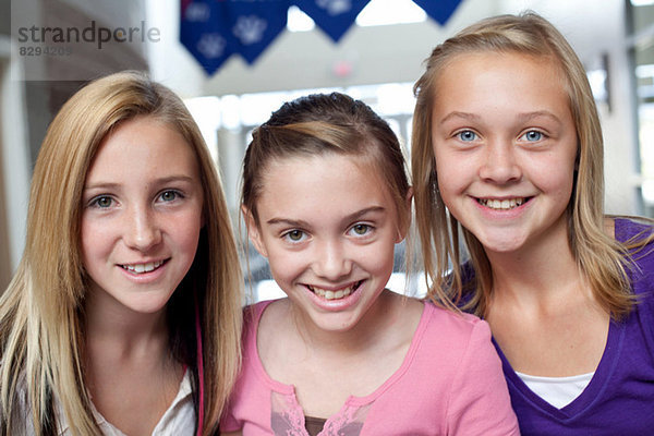 Nahaufnahme von drei lächelnden Teenagern und vorpubertären Mädchen