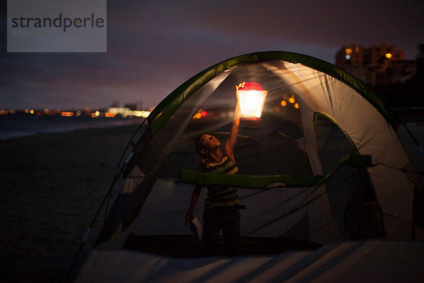 Junge im Zelt mit Schoß bei Nacht  Huntington Beach  Kalifornien  USA