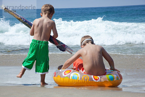 Zwei junge Brüder spielen am Strand