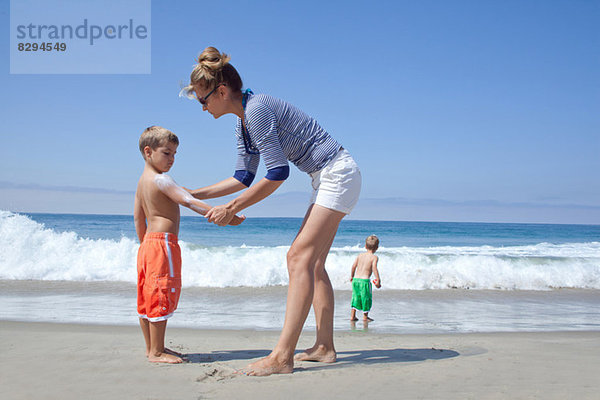 Mutter und Söhne am Strand