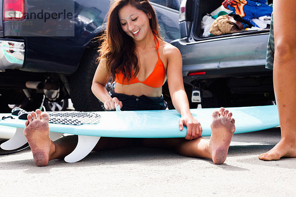 Frau sitzend mit Surfbrett  Hermosa Beach  Kalifornien  USA
