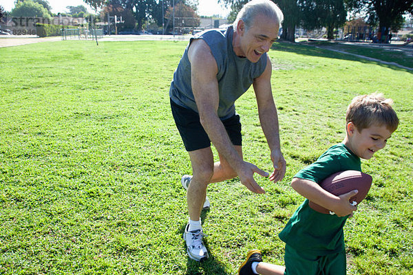 Junge und Großvater spielen American Football