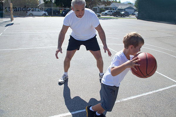 Mann und Enkel beim Basketballspielen