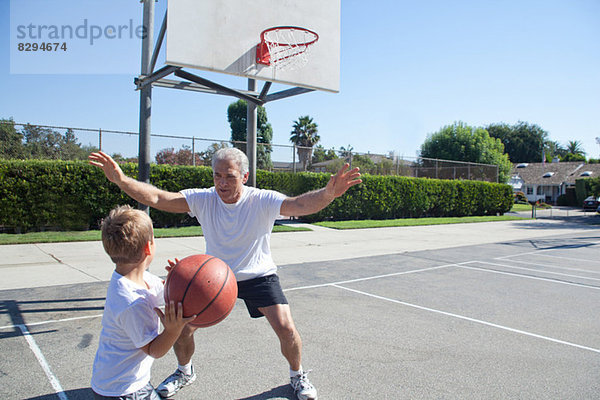 Junge und Großvater spielen Basketball