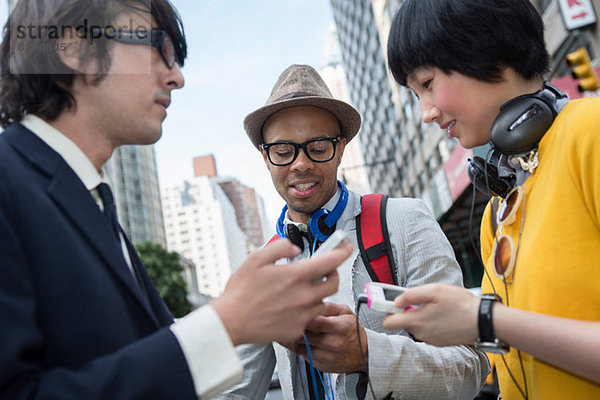 Drei Freunde auf der Straße mit mp3-Player