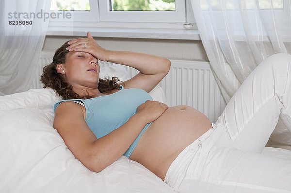 junge schwangere Frau mit Kopfschmerzen