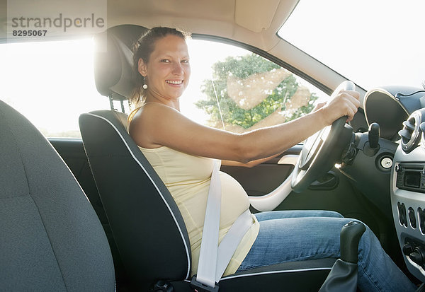 junge schwangere Frau beim Autofahren
