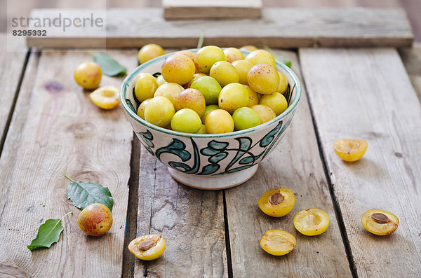 Mirabelles in a bowl on a wooden tray