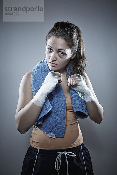 Porträt einer jungen Boxerin mit erhobenen Fäusten
