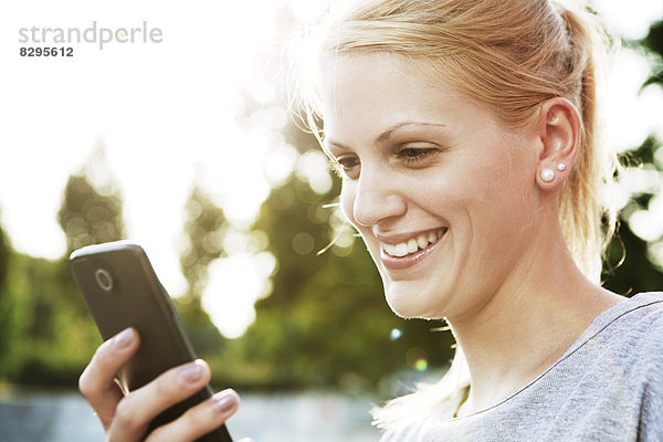 Lächelnde junge Frau mit Smartphone
