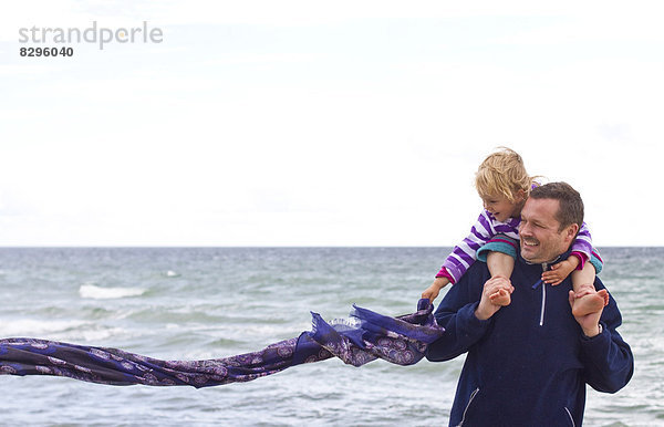 Danmark  Ringkoebing  kleines Mädchen mit ihrem Vater am Strand  Schal fliegend