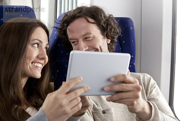 Paar mit digitalem Tablett in einem Zug