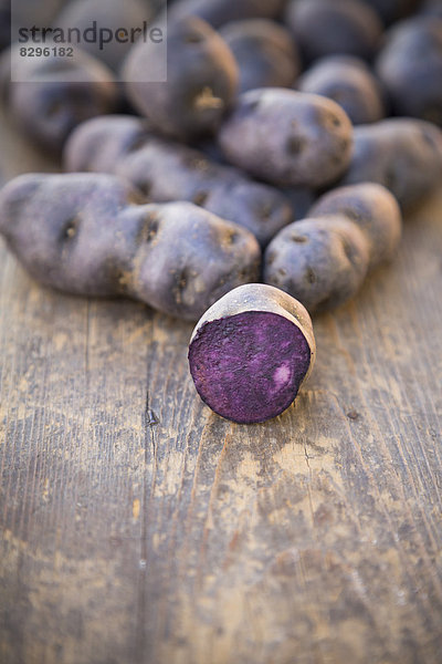Truffle de Chine blue-violet potatoes on wooden table