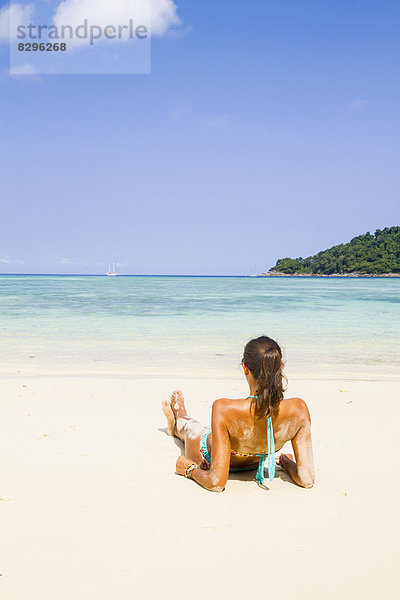 Thailand  Koh Surin island  woman lying at white sandy beach