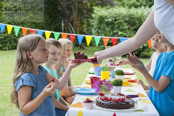 Girl receiving piece of cake on a birthday party