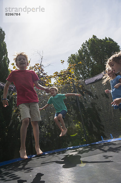 Kinder hüpfen auf Trampolin