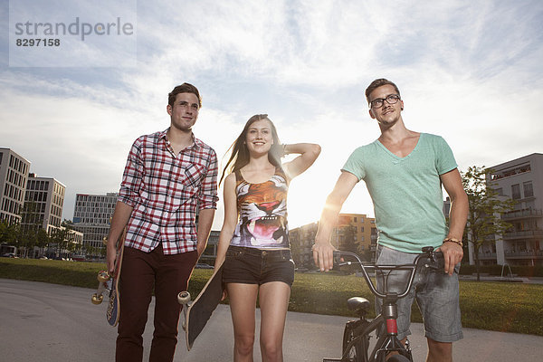 Deutschland  Bayern  München  Freunde wandern mit Skateboard und BMX Fahrrad