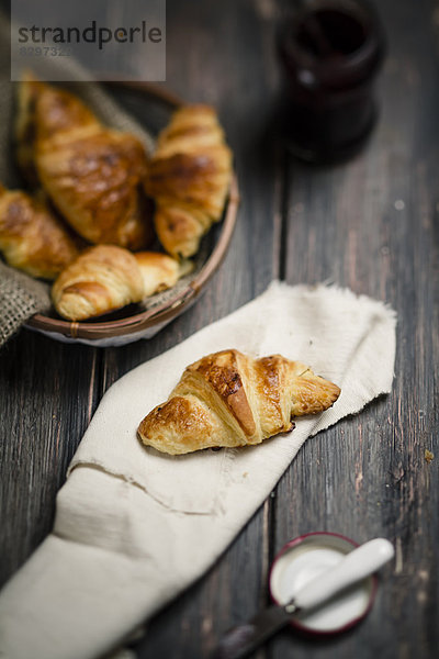 Croissants and jam on wooden table  studio shot