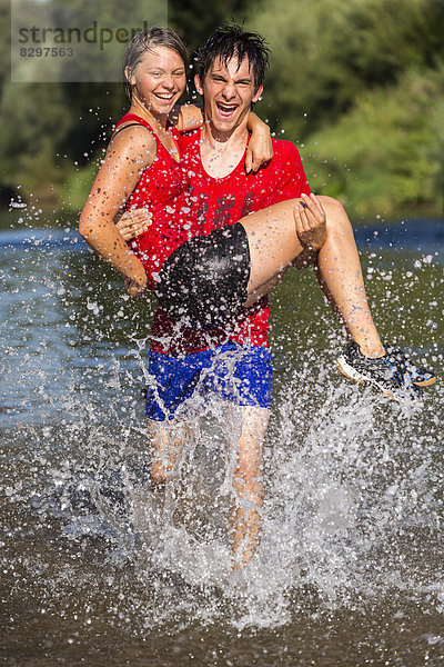 sportlicher junger Mann mit junger Frau beim Laufen durch den Rems-Fluss