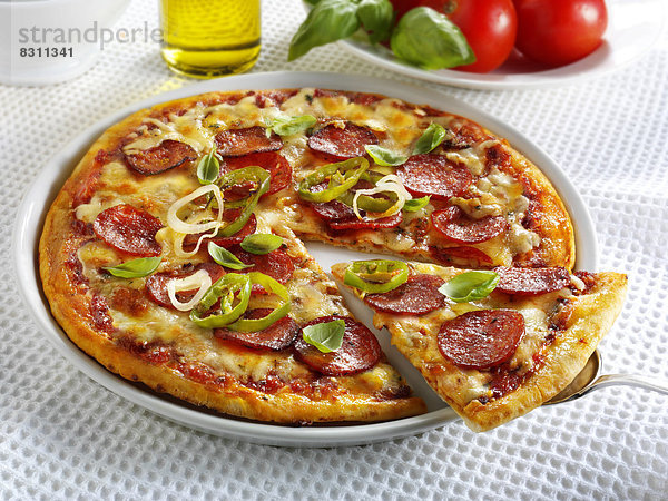 Pizza mit Salami  Käse  Chilis und Basilikum