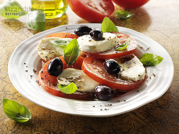 Salat mit Büffel-Mozzarella  Tomaten  Oliven und Basilikum