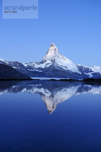 Matterhorn spiegelt sich im Stellisee in der Dämmerung