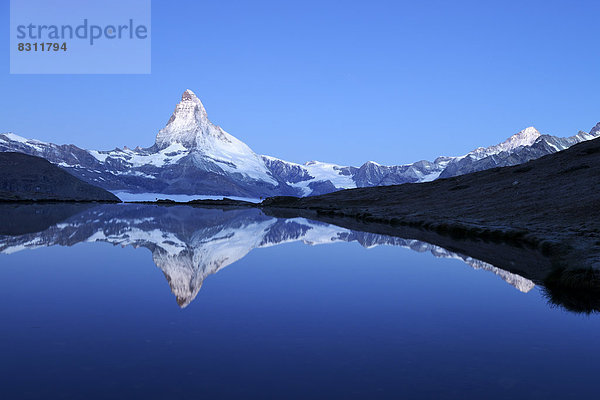 Matterhorn spiegelt sich im Stellisee in der Dämmerung