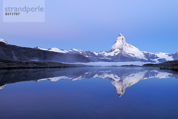 Matterhorn spiegelt sich im Stellisee in der Dämmerung