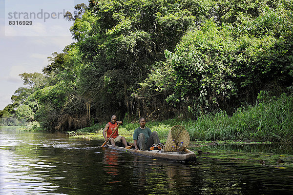 Ein Fischer ist mit seiner Frau auf dem Fluss Nyong unterwegs  um Reusen auszulegen