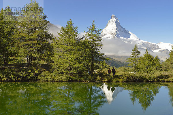 Wanderer am Grindjisee stehend  hinten das Matterhorn