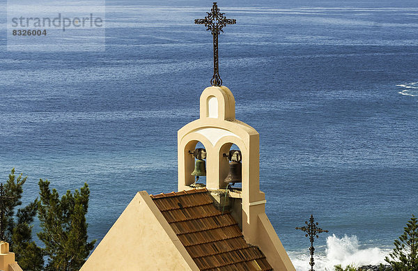 Kirchturmspitze der Kirche Santiago Apostol  hinten das Meer