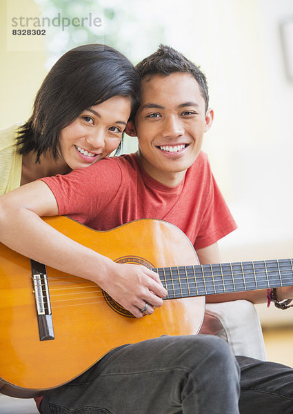 Portrait of young couple  man holding guitar